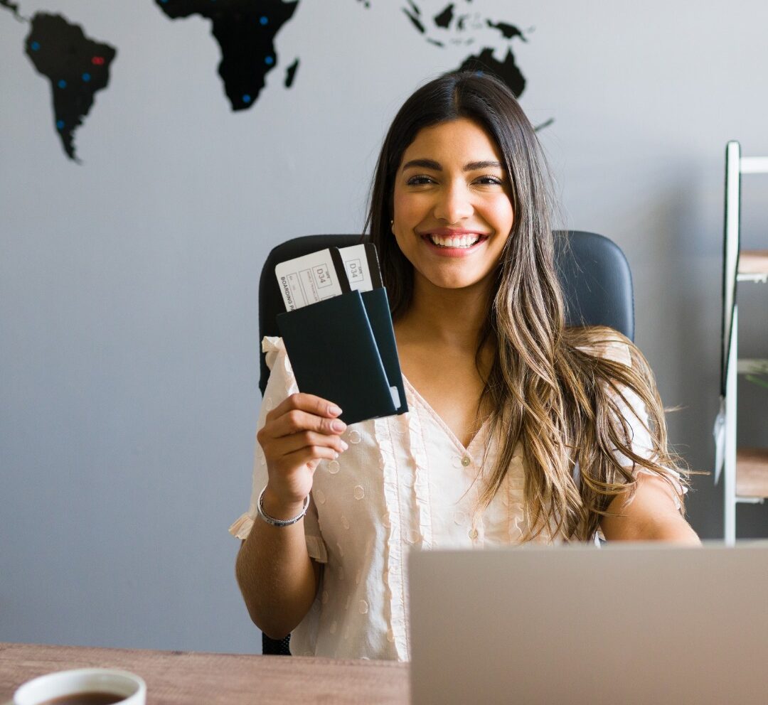 Woman travel agent holding two passports and smiling